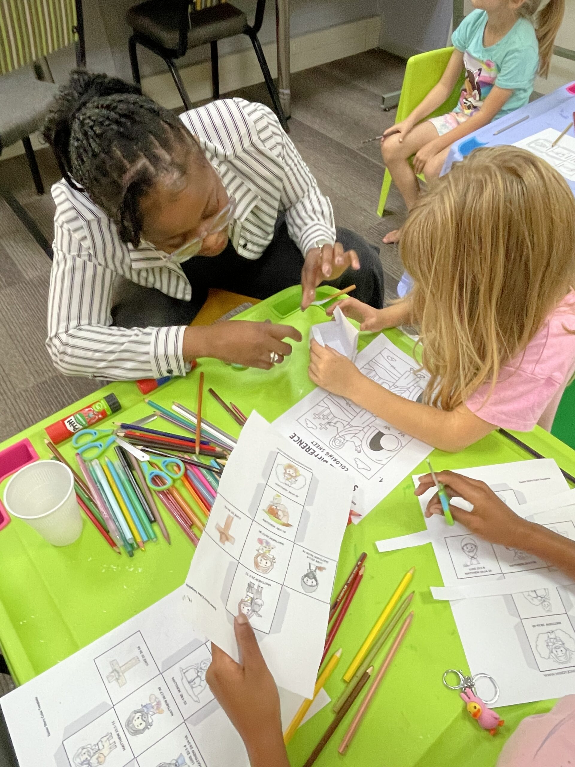 Small group leader helping with craft at table