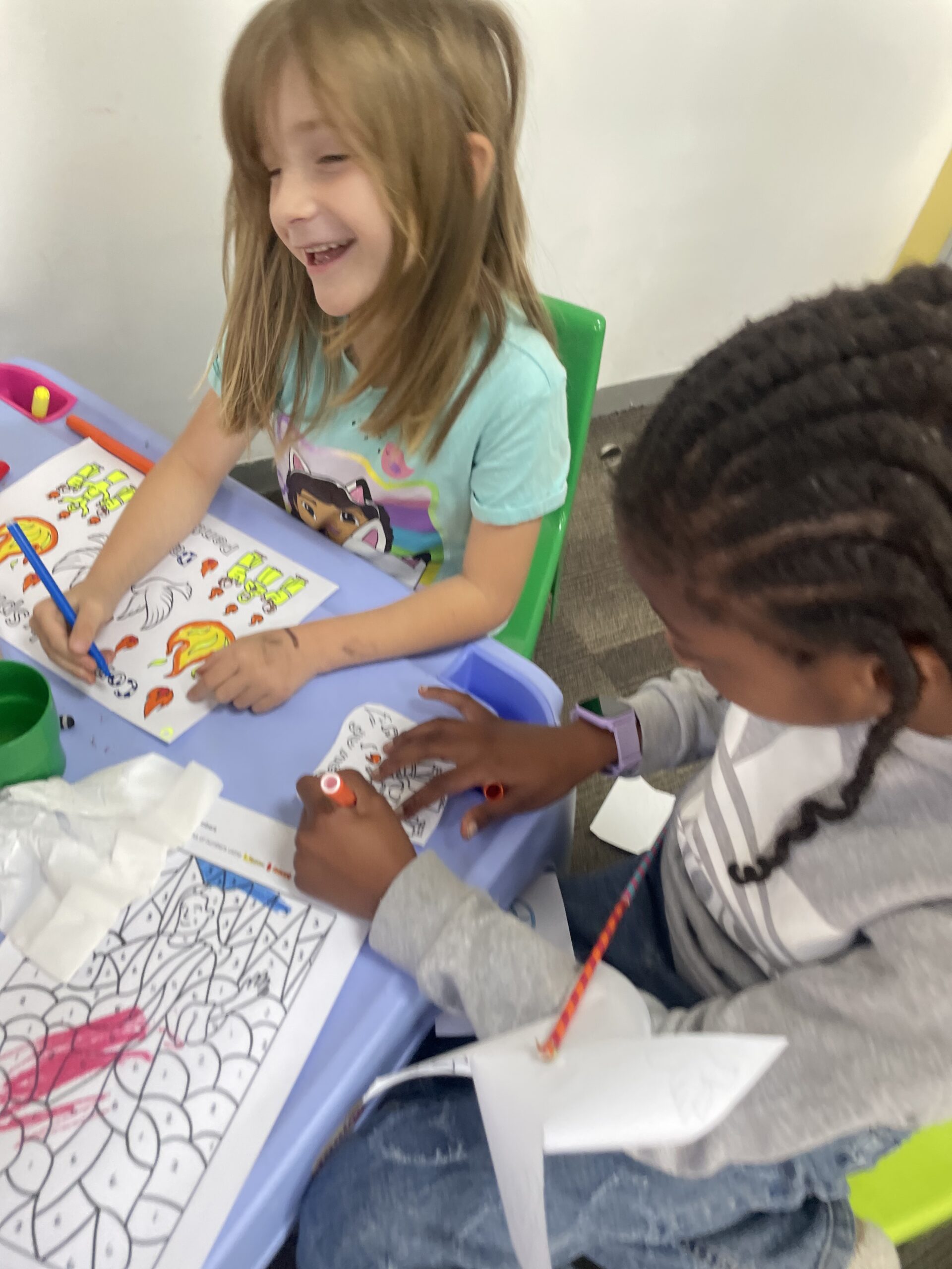 Two girls laughing coloring together friendship
